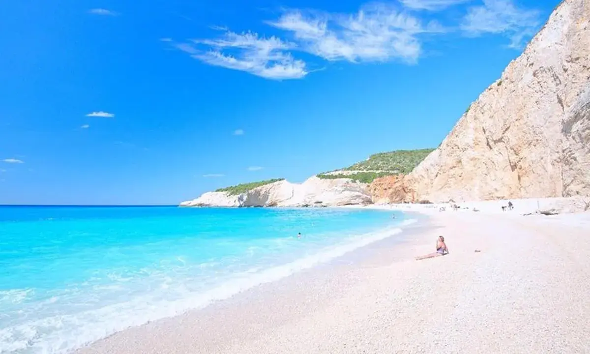 Rajskie lefkada plaże z turkusową wodą i białym piaskiem. Kobieta odpoczywa na plaży, podziwiając widok.