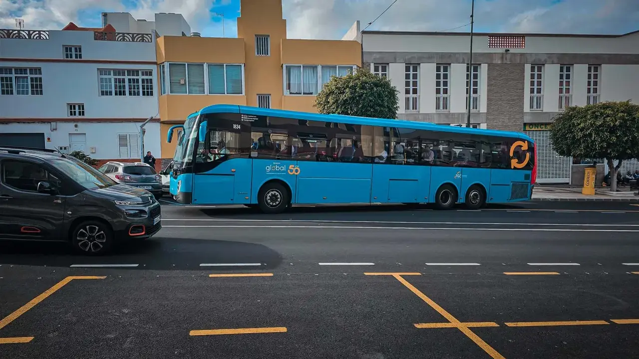 Błękitny autobus firmy Global 50, jeden z wielu gran canaria autobusy, jedzie ulicą.