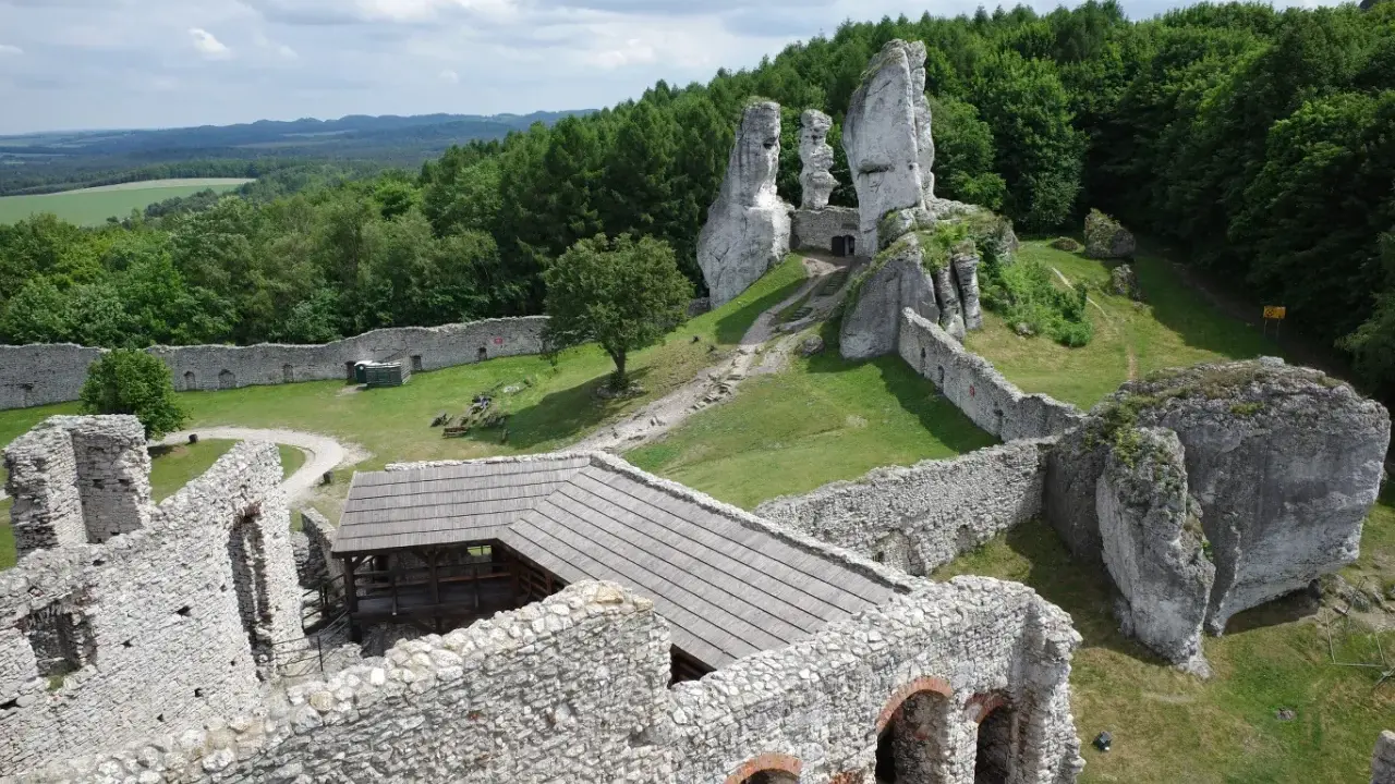 Ruiny zamku na skale, zielone wzgórza i lasy. Wspaniałe **ogrodzieniec atrakcje** dla miłośników historii i przyrody.