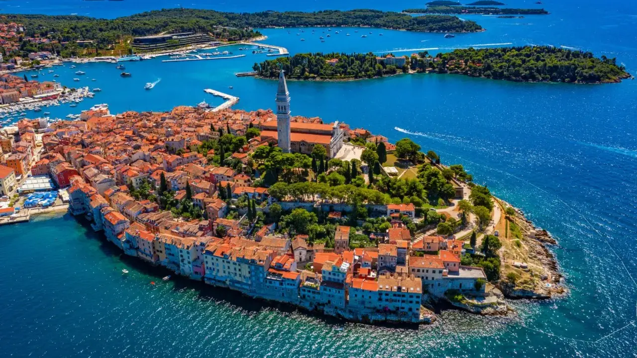Malownicze miasteczko na półwyspie Istria, z charakterystyczną wieżą kościelną górującą nad czerwonymi dachami.