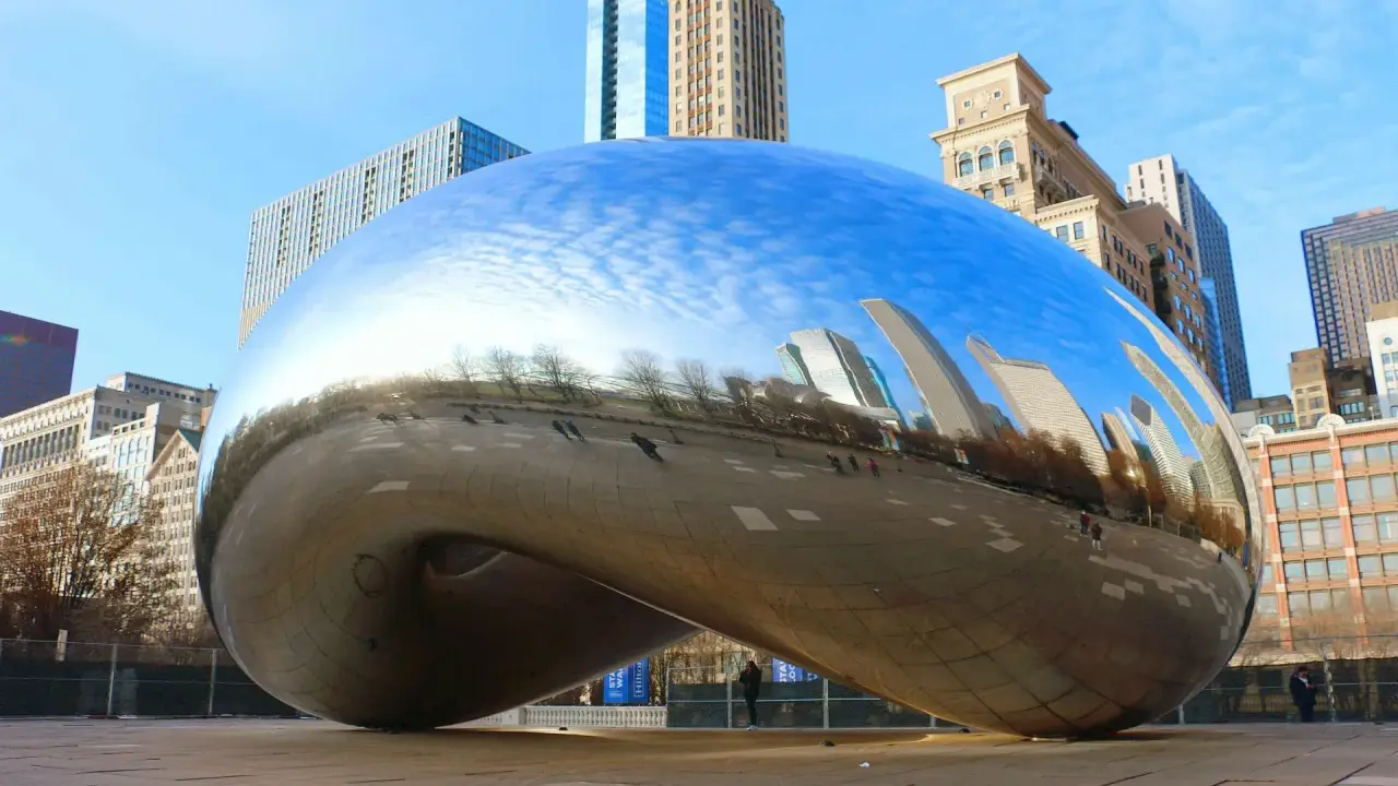 Chicagowskie atrakcje i okolice: Błyszcząca fasola Cloud Gate odbija drapacze chmur i błękitne niebo.