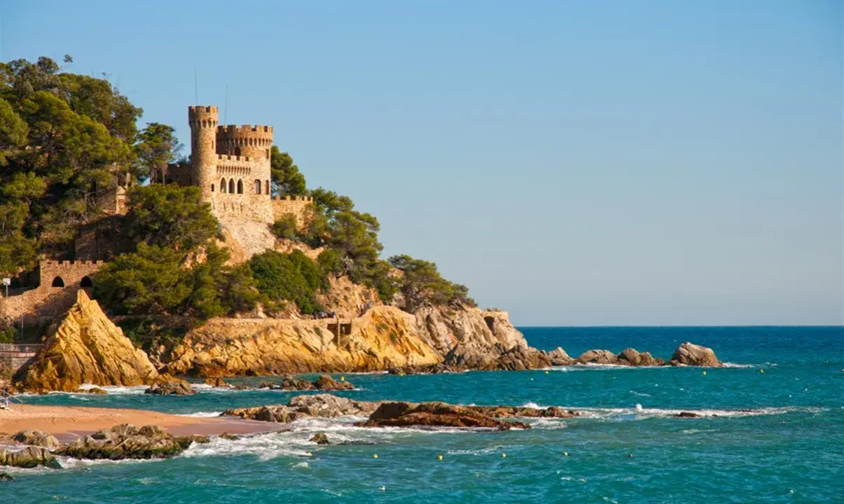 Zamek na klifie nad turkusowym morzem, malownicze costa brava plaże.