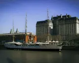 Żaglowiec cumuje przy nabrzeżu, a w tle widać zabytkowe budynki. To idealne miejsce, by poczuć klimat Buenos Aires co zobaczyć.