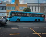 Błękitny autobus firmy Global 50, jeden z wielu gran canaria autobusy, jedzie ulicą.