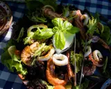 Pyszne owoce morza z sałatką i sosem, serwowane na talerzu w jednej z restauracji na słonecznym brzegu.