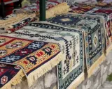 Kolorowe, tradycyjne kilimy z frędzlami. Idealne pamiątki, by poczuć klimat Albanii. Co przywieźć z Albanii? Taki kilim!