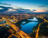 Wieczorny widok na rozświetlone miasto i trzy stawy w Dolinie Trzech Stawów w Katowicach.