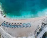 Rajska plaża na Thassos z turkusową wodą i rzędami leżaków. Idealne miejsce na relaks i podziwianie pięknych widoków.