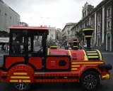 Czerwony turystyczny pociąg na ulicach Sycylii, oferujący nietypową komunikację miejską.