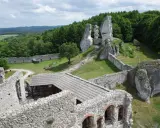 Ruiny zamku na skale, zielone wzgórza i lasy. Wspaniałe **ogrodzieniec atrakcje** dla miłośników historii i przyrody.