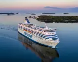 Duży prom Silja Line płynie po spokojnym morzu, tworząc fale. To podróż między Tallinem a Helsinkami.