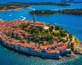 Malownicze miasteczko na półwyspie Istria, z charakterystyczną wieżą kościelną górującą nad czerwonymi dachami.