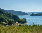 Malowniczy park krajobrazowy Małopolska z zamkiem na wzgórzu, jeziorem i łodziami.