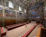 Wnętrze kaplicy Sykstyńskiej z malowidłami Michała Anioła, rzędami stołów i krzeseł gotowych na ważne spotkanie.