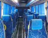 Wygodne siedzenia w autobusie, idealne na transport między Tiraną a Durrës. Błękitne zasłony i wzorzyste obicia dodają uroku.