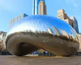 Chicagowskie atrakcje i okolice: Błyszcząca fasola Cloud Gate odbija drapacze chmur i błękitne niebo.