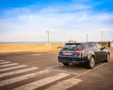 Ciemny kombi zaparkowany przy plaży, gotowy na długą trasę Polska-Hiszpania samochodem.