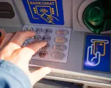 Dłoń wpisuje PIN na bankomacie w Turcji. Szukaj bankomatów bez prowizji, by oszczędzić na wakacjach.