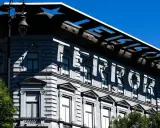 Budapeszt: Muzeum Terroru, budynek z napisem "TERROR" na fasadzie, odbijającym się w słońcu.