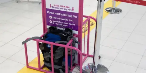 Wizzair leki w bagażu podręcznym? Sprawdź wymiary w różowym stojaku. Plecaki czekają na pomiar.