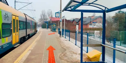 Pociąg na stacji, strzałki wskazują drogę. Tak jak dojechać z Krakowa do Wieliczki.
