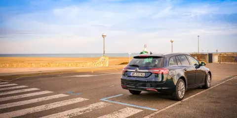 Ciemny kombi zaparkowany przy plaży, gotowy na długą trasę Polska-Hiszpania samochodem.