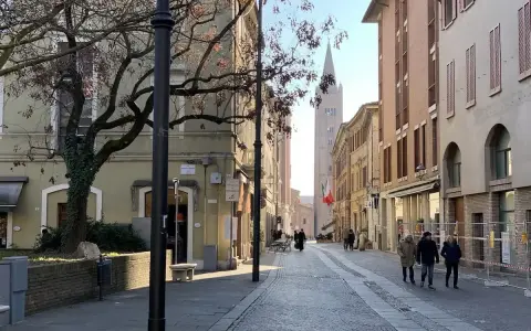 Spacerem po urokliwej uliczce w Forlì, Włochy. W oddali widać wieżę kościelną i włoską flagę.