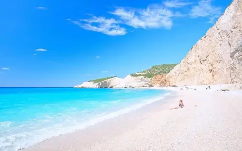 Rajskie lefkada plaże z turkusową wodą i białym piaskiem. Kobieta odpoczywa na plaży, podziwiając widok.