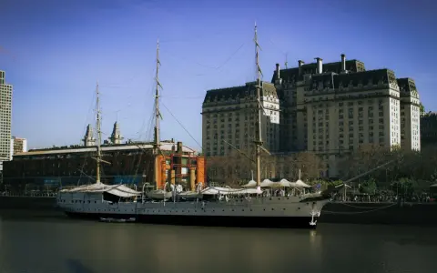 Żaglowiec cumuje przy nabrzeżu, a w tle widać zabytkowe budynki. To idealne miejsce, by poczuć klimat Buenos Aires co zobaczyć.