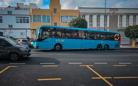 Błękitny autobus firmy Global 50, jeden z wielu gran canaria autobusy, jedzie ulicą.