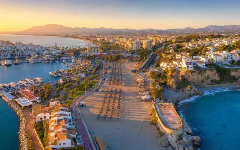 Widok na port jachtowy i plażę w słoneczny dzień. Idealne miejsce, by odkryć, co warto zobaczyć na Costa del Sol.