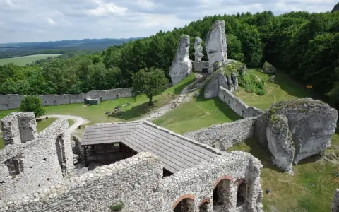Ruiny zamku na skale, zielone wzgórza i lasy. Wspaniałe **ogrodzieniec atrakcje** dla miłośników historii i przyrody.