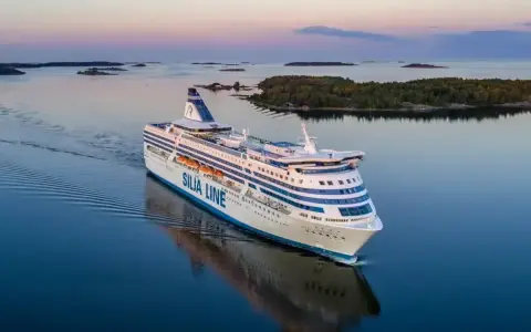 Duży prom Silja Line płynie po spokojnym morzu, tworząc fale. To podróż między Tallinem a Helsinkami.