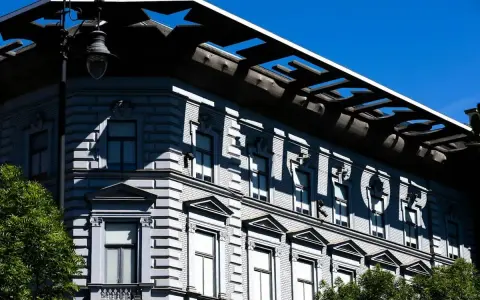 Budapeszt: Muzeum Terroru, budynek z napisem "TERROR" na fasadzie, odbijającym się w słońcu.