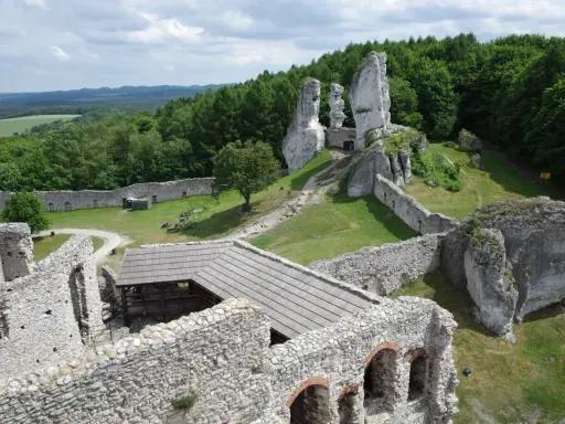 Ruiny zamku na skale, zielone wzgórza i lasy. Wspaniałe **ogrodzieniec atrakcje** dla miłośników historii i przyrody.