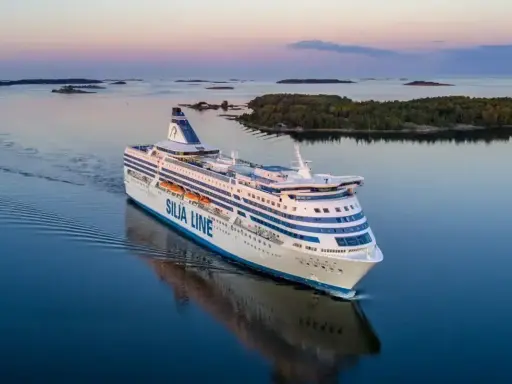 Duży prom Silja Line płynie po spokojnym morzu, tworząc fale. To podróż między Tallinem a Helsinkami.
