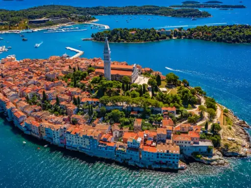 Malownicze miasteczko na półwyspie Istria, z charakterystyczną wieżą kościelną górującą nad czerwonymi dachami.