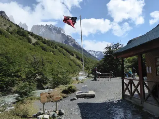Wspaniałe widoki w Chile! Flaga powiewa nad chatką, a w tle majestatyczne góry. Idealne miejsce, by zobaczyć cuda natury.