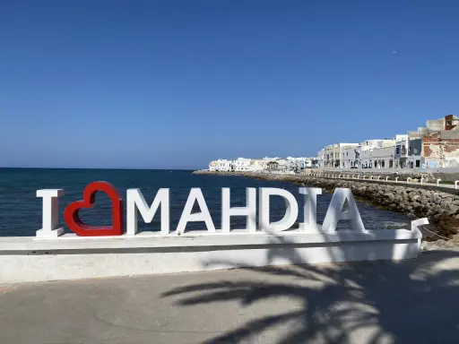 Mahdia Tunezja co warto zobaczyć? Napis "I ❤️ MAHDIA" na tle morza i białych budynków.