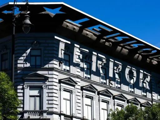 Budapeszt: Muzeum Terroru, budynek z napisem "TERROR" na fasadzie, odbijającym się w słońcu.