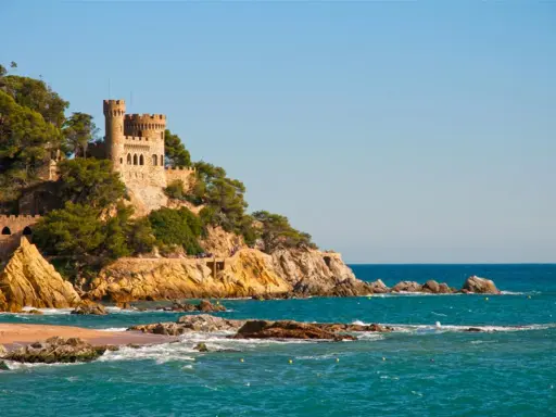Zamek na klifie nad turkusowym morzem, malownicze costa brava plaże.