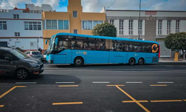 Błękitny autobus firmy Global 50, jeden z wielu gran canaria autobusy, jedzie ulicą.