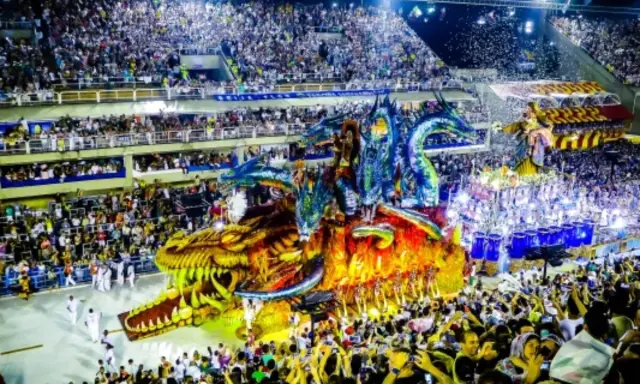 Smok i smoki na platformie, tłumy wiwatują na karnawale w Rio 2024.