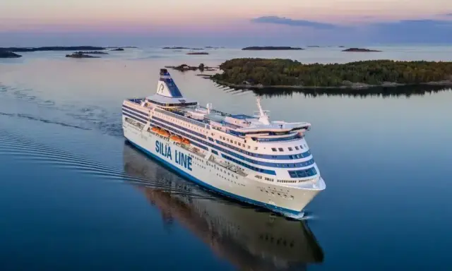 Duży prom Silja Line płynie po spokojnym morzu, tworząc fale. To podróż między Tallinem a Helsinkami.