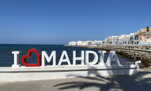 Mahdia Tunezja co warto zobaczyć? Napis "I ❤️ MAHDIA" na tle morza i białych budynków.