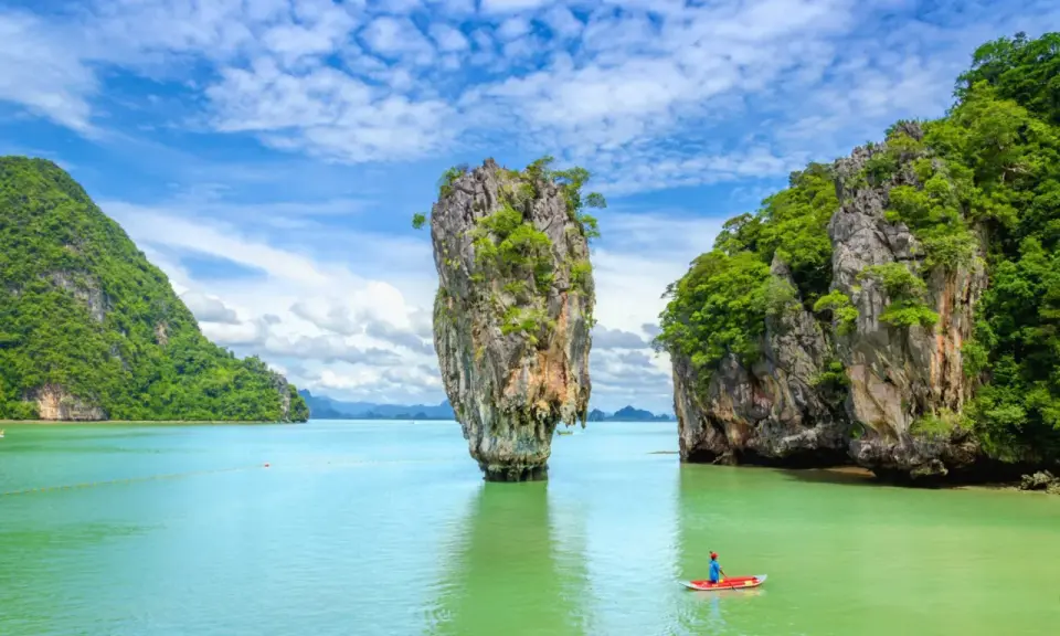 Wyspa Phuket, Tajlandia: samotna skała wyrasta z turkusowej wody, a kajakarz podziwia krajobraz.