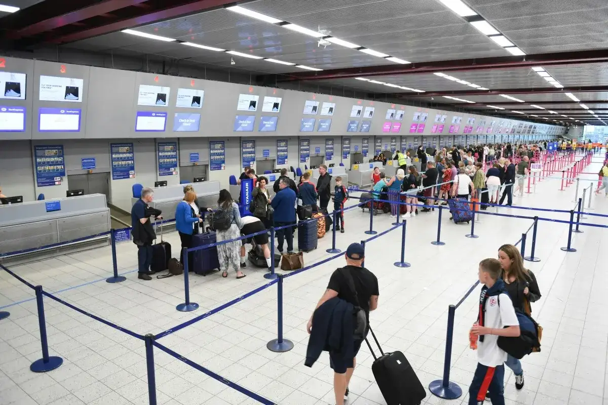 Kolejka do odprawy na lotnisku. Ludzie z bagażami czekają na swój pierwszy lot samolotem Ryanair.