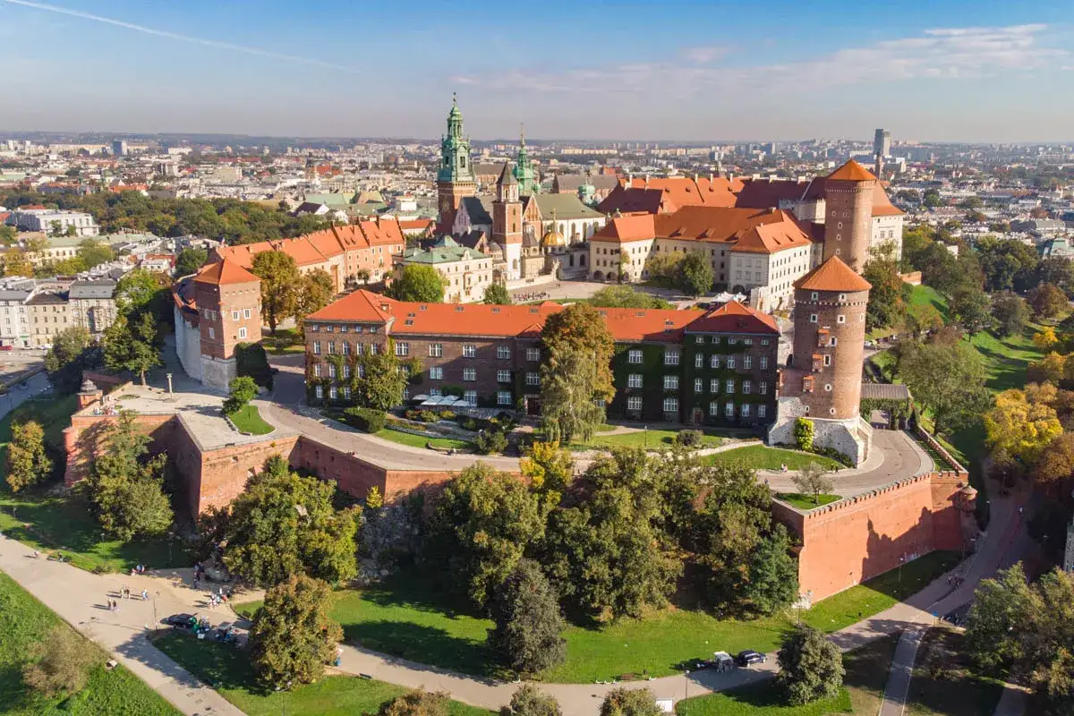 Wawel w Krakowie, majestatyczny zamek i katedra na wzgórzu, otoczony murami obronnymi i zielenią.