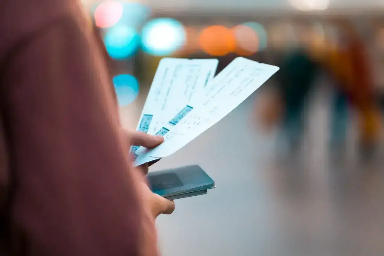 Ręka trzyma bilety lotnicze i paszport. Zastanawiasz się, czy można zwr&oacute;cić bilety Ryanair?