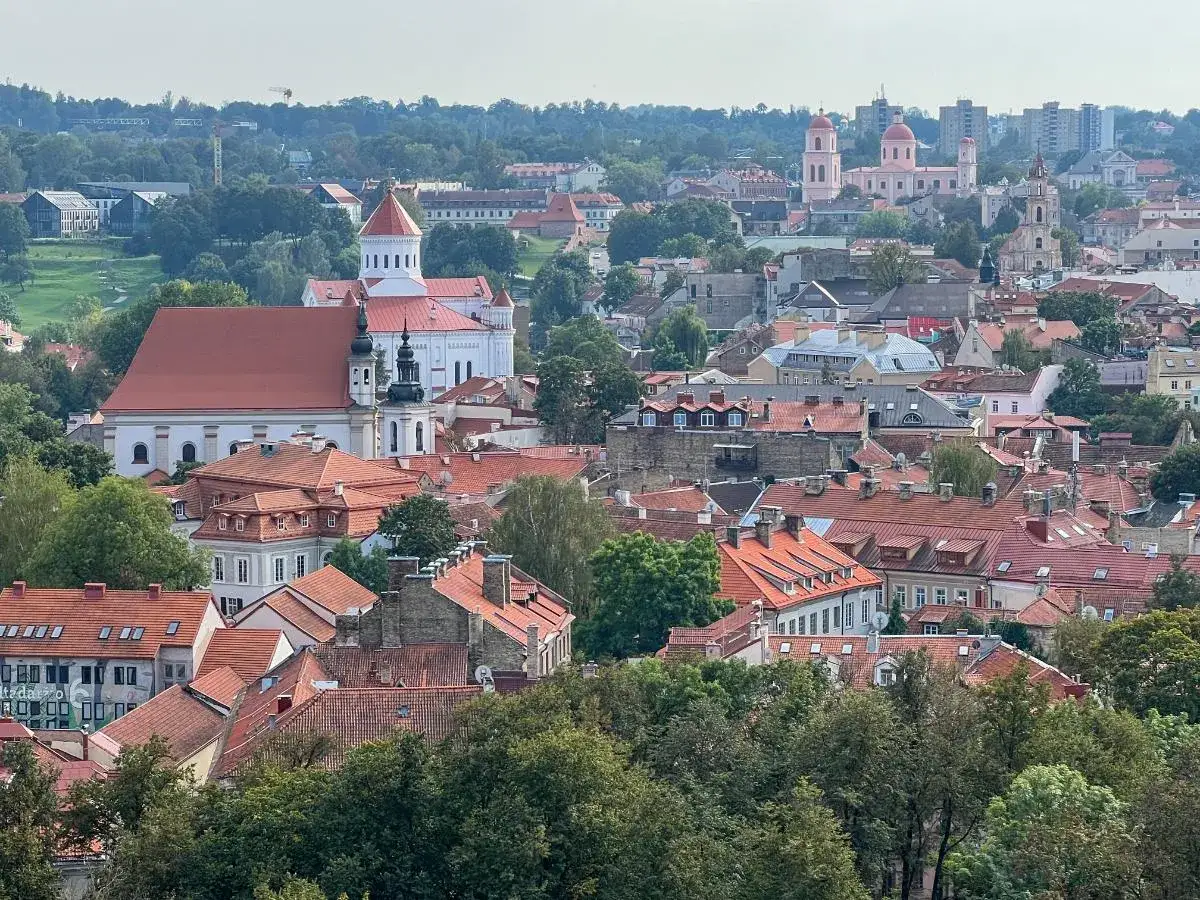 Widok na zabytkowe centrum Wilna z czerwonymi dachami i kościołami. Idealne miejsce, by zobaczyć, co zobaczyć w Wilnie.